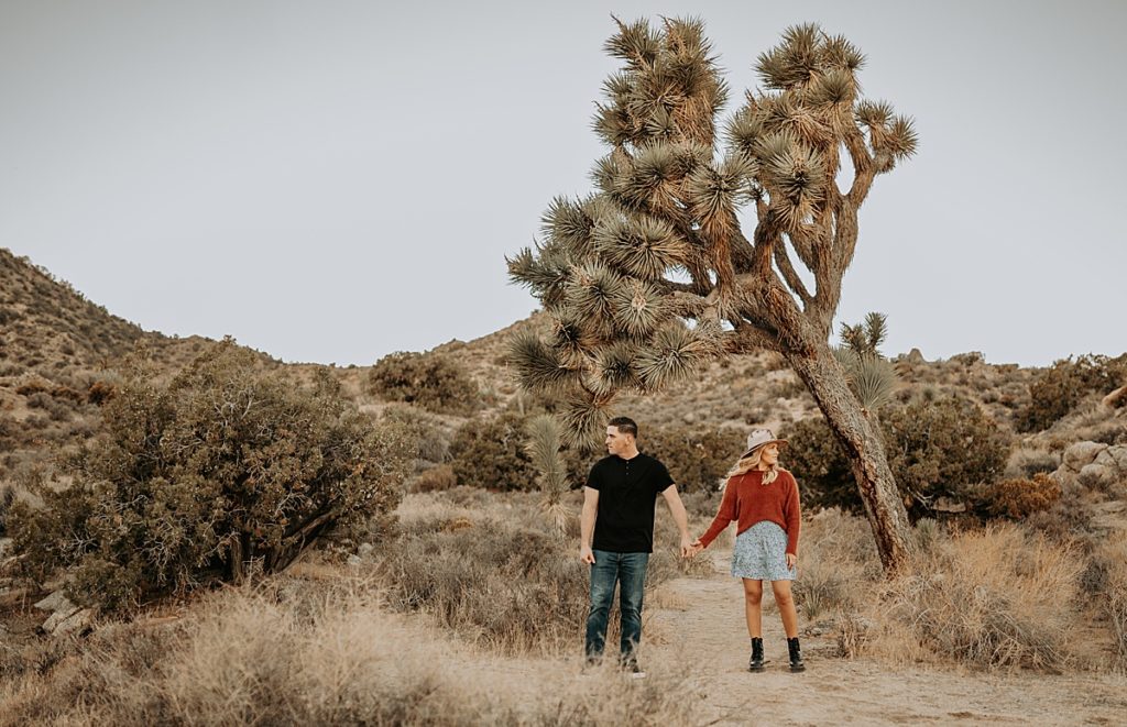 couple holding hands during engagement photoshoot in Joshua Tree