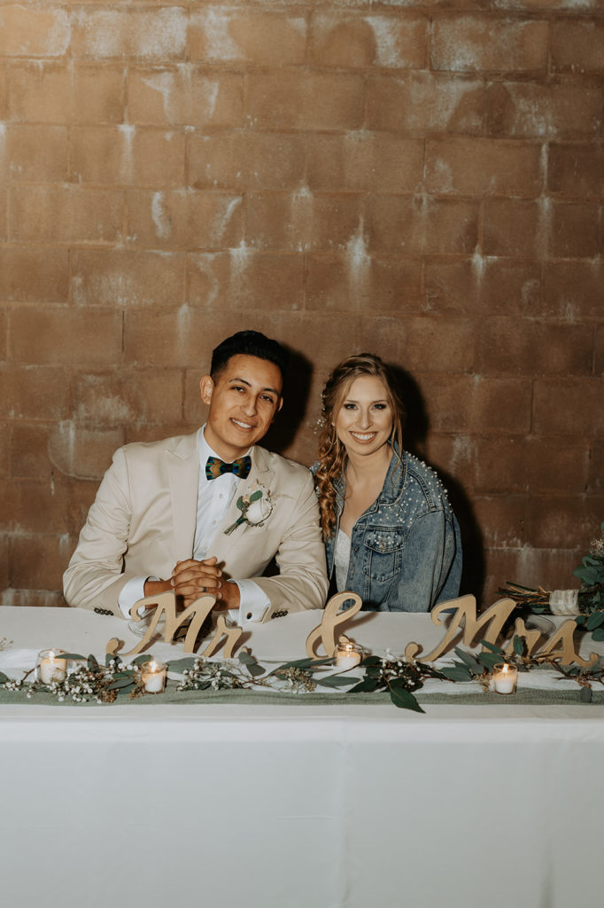 bride and groom at their sweetheart table with mr and mrs sign