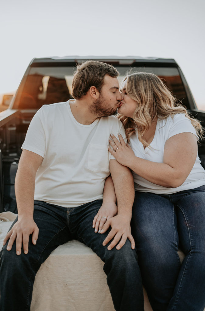 couple sitting on truck at desert