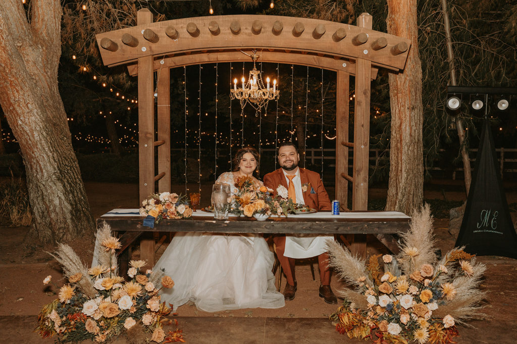 bride and groom posing at their wedding table