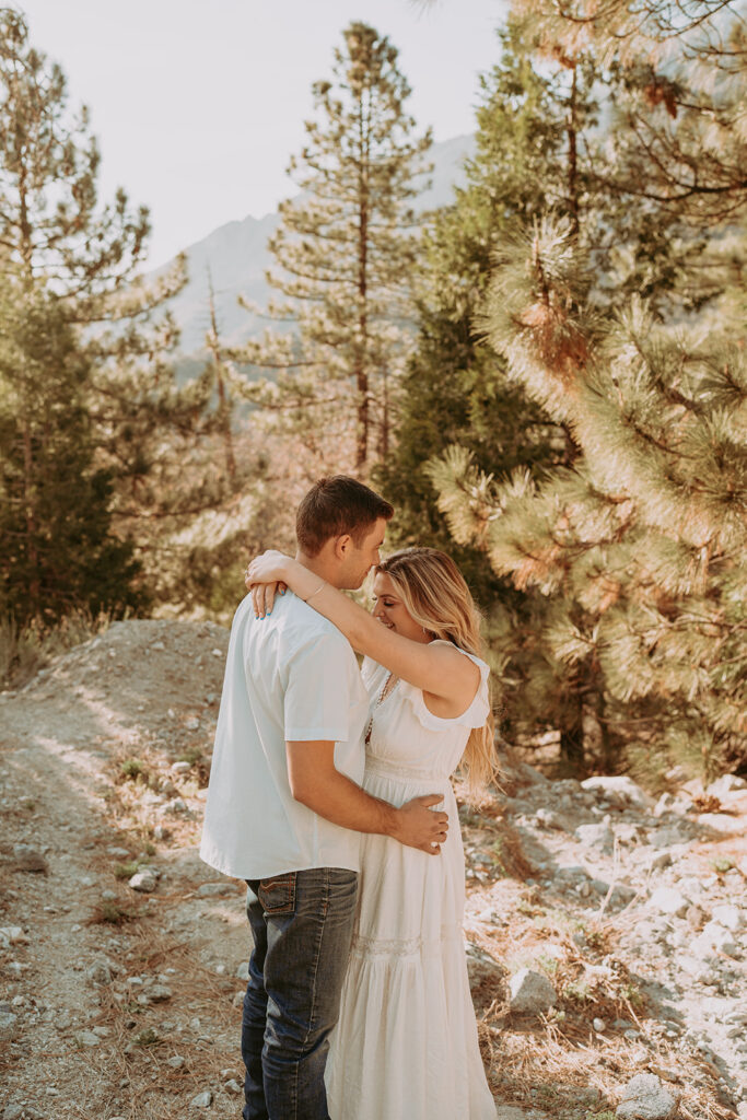 Couple posing for their engagement photos in forest falls ca - rustic engagement photos
