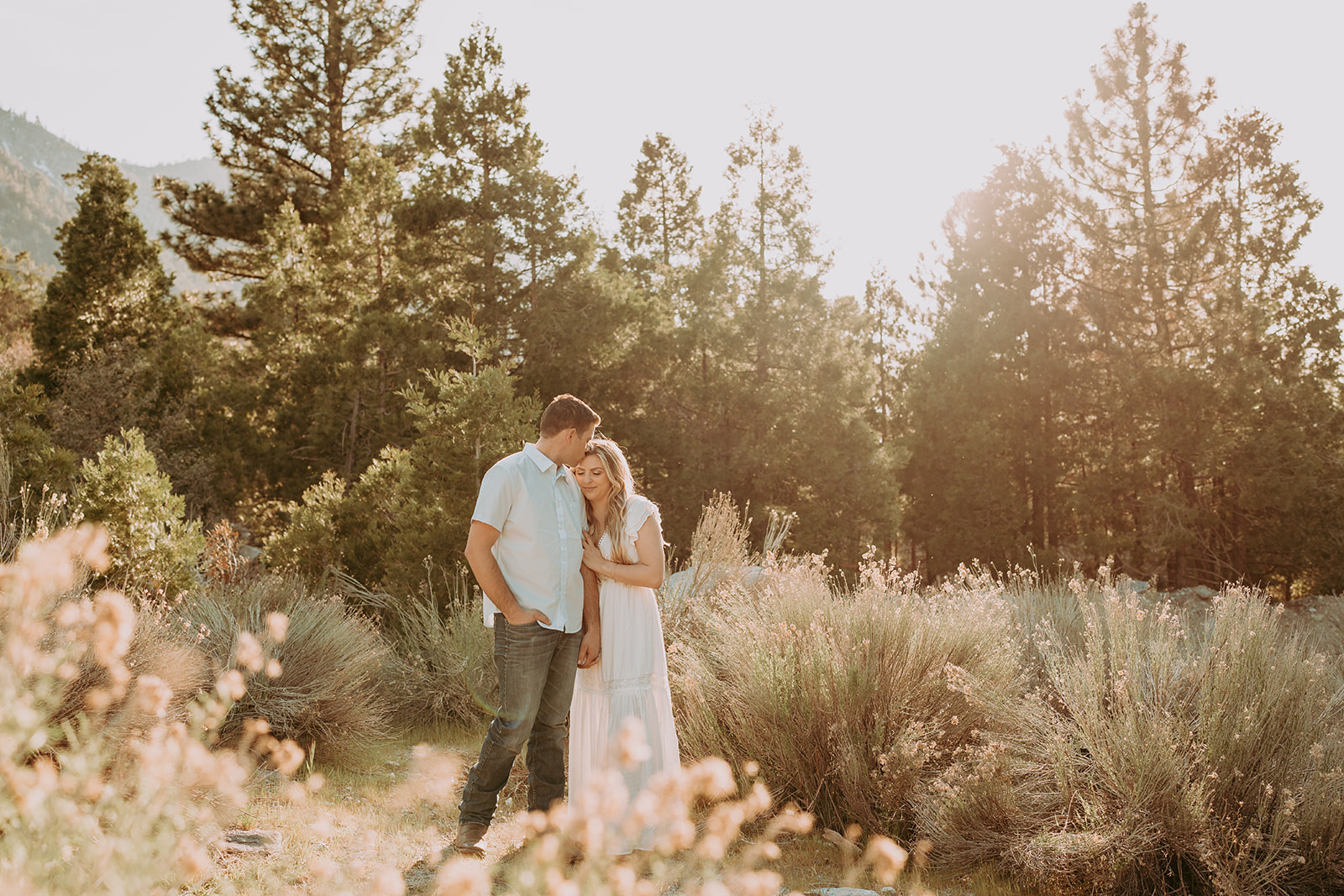 Couple posing for their engagement photos in forest falls ca - rustic engagement photos