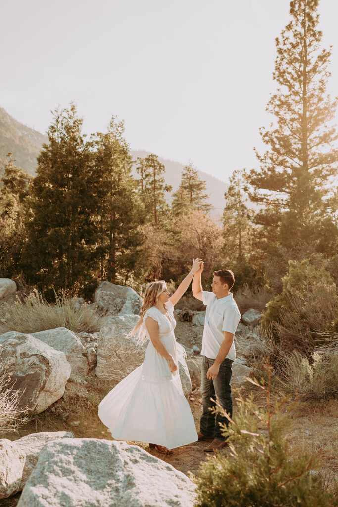 Couple posing for their engagement photos in forest falls ca - rustic engagement photos