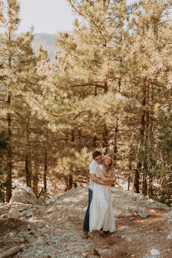 couple in forest falls ca posing for their engagement photos in the mountains

