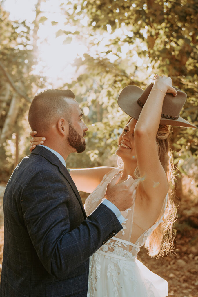 Wedding couple laughing with a cowboy hat