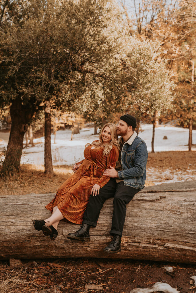 couple sitting for fall mountain engagement session