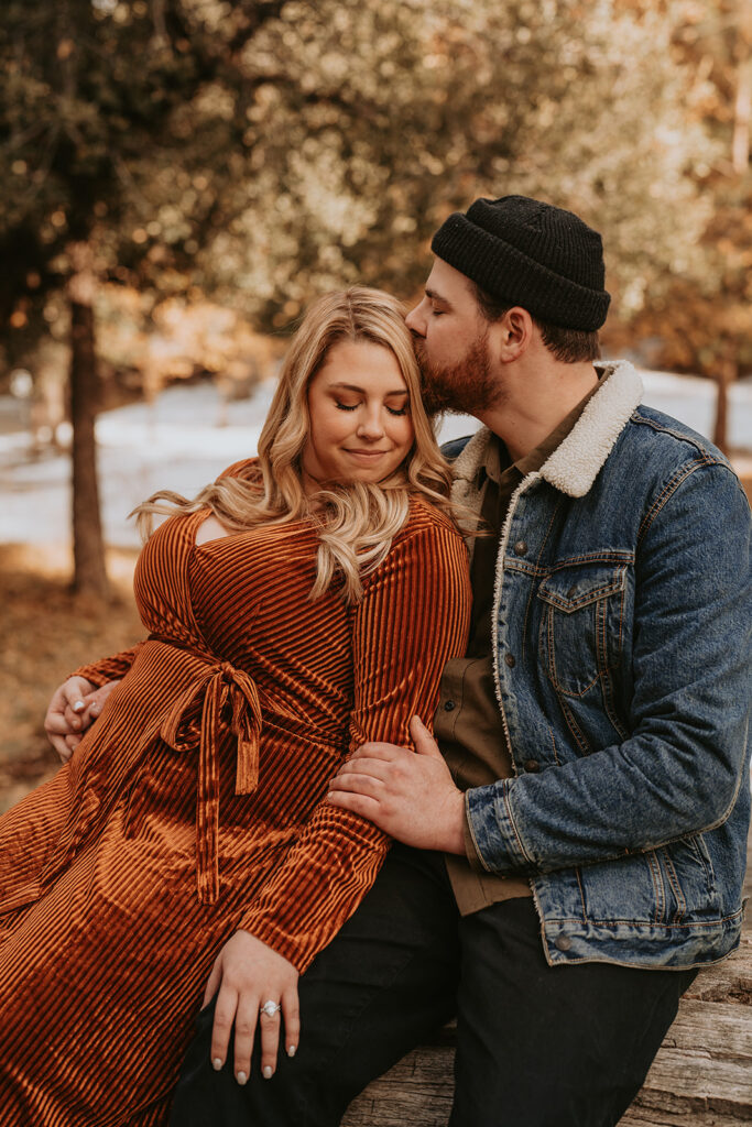 Couple sitting for a mountain winter engagement session