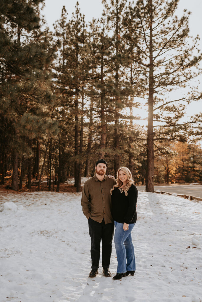 couple standing for winter mountain engagement session