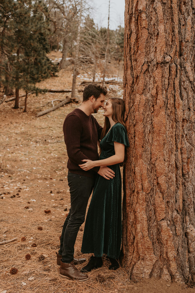 Couple embracing next to a tree in the winter
