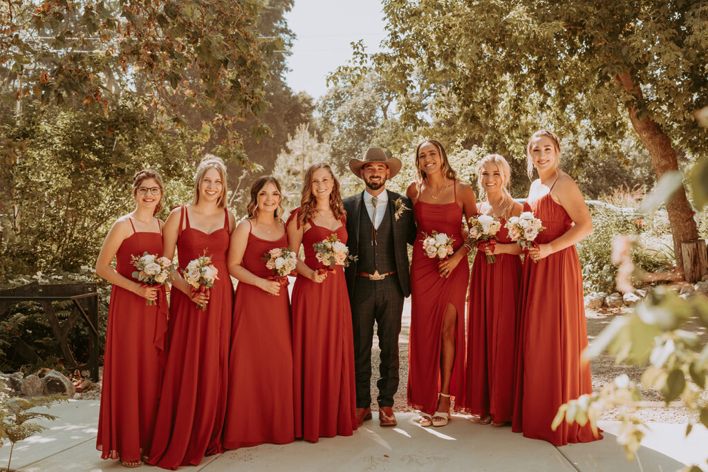 Groom standing with bridesmaids
