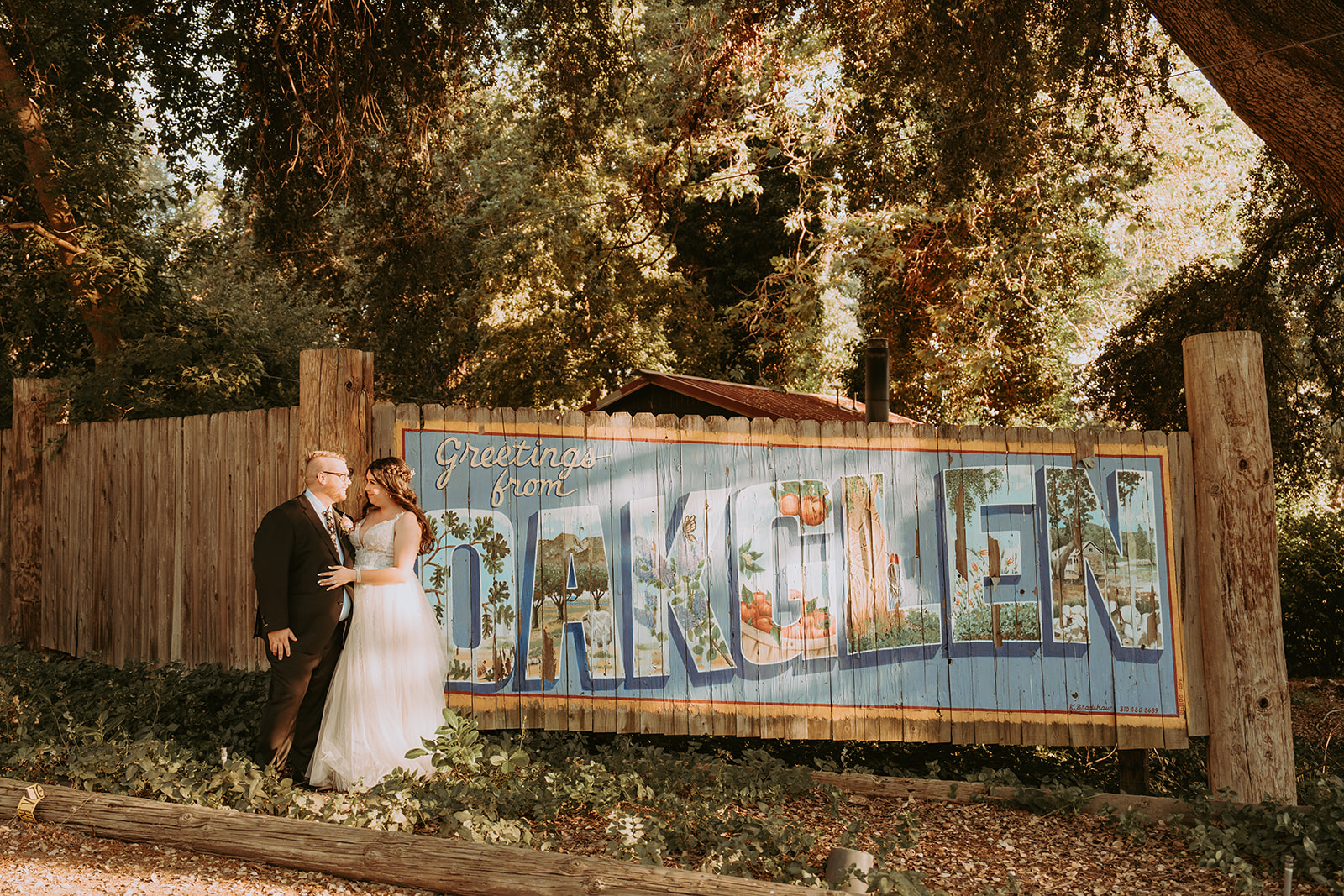 Bride and Groom Standing in front of Oak Glen Sign