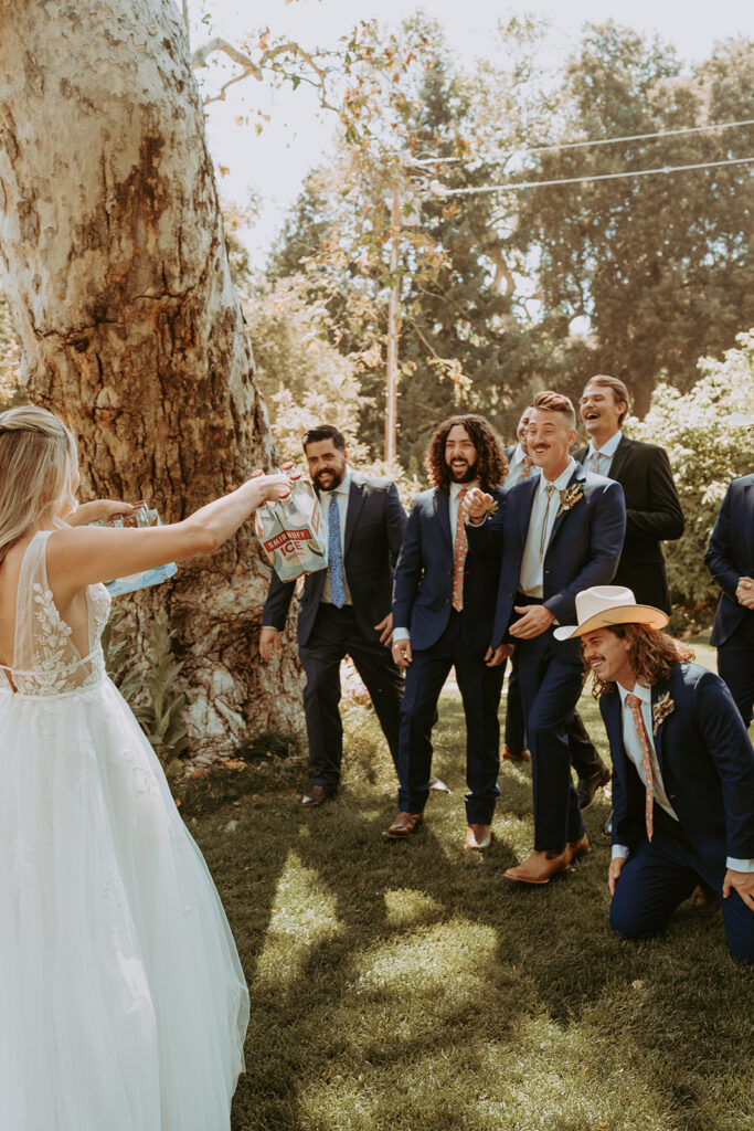 bride icing groomsmen in Oak Glen