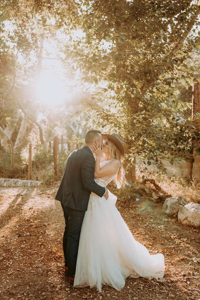groom kissing a bride at a Southern California wedding venue in Oak Glen