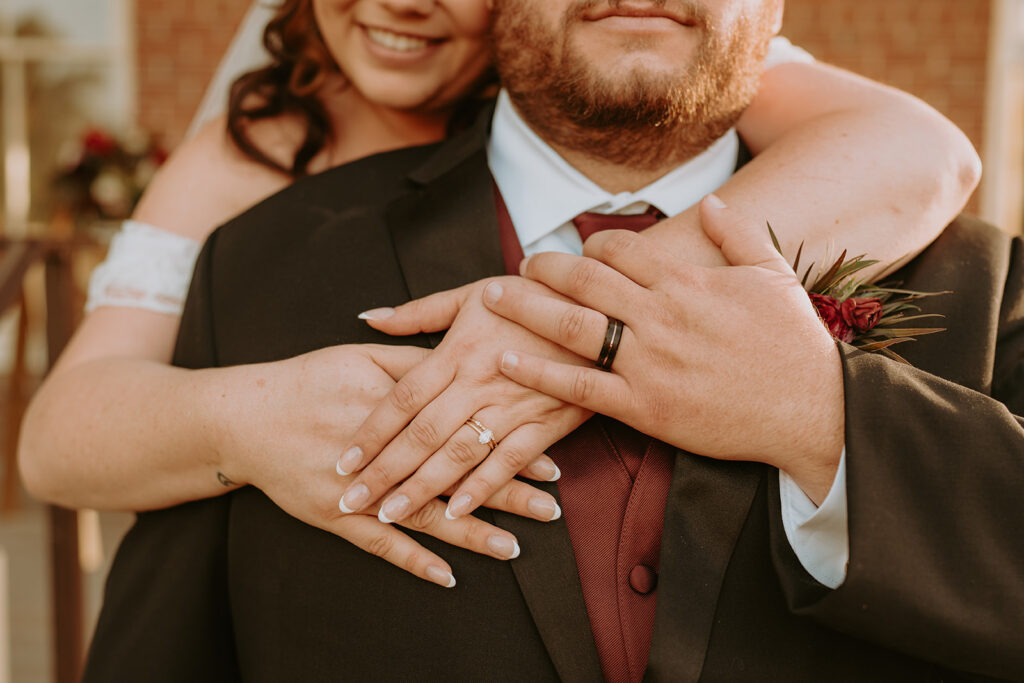 bride and groom embracing with rings