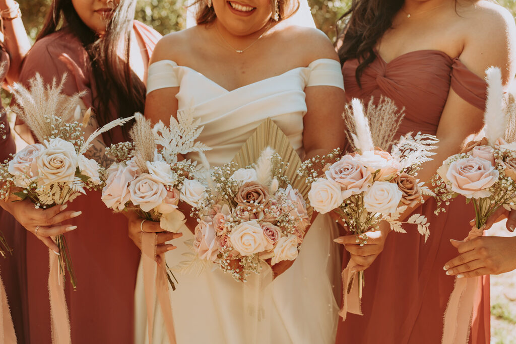 bride in her dress with a light pink rose bouquet
