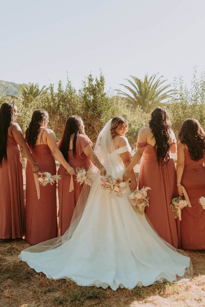 bride with her bridesmaids with bouquets