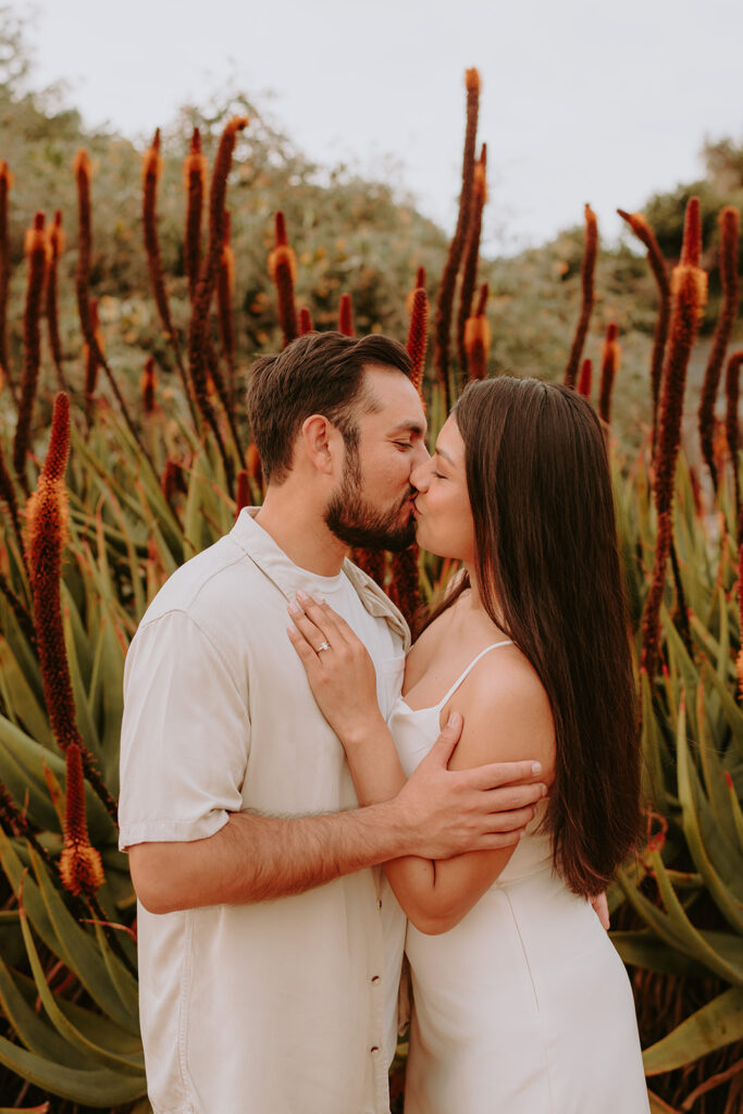 couple kissing for engagement photos at the Los Angeles arboretum
