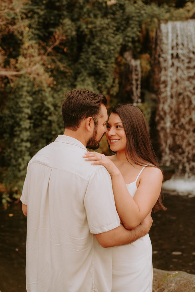 engaged couple in front of a waterfall at the Los Angeles arboretum