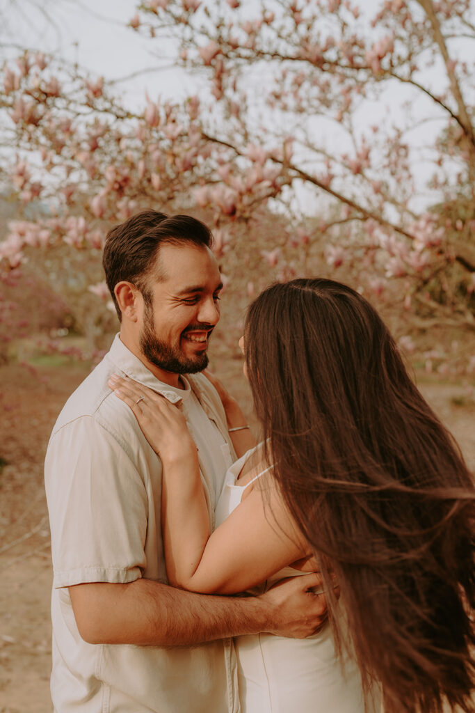 engaged couple smiling at each other for engagement photos 