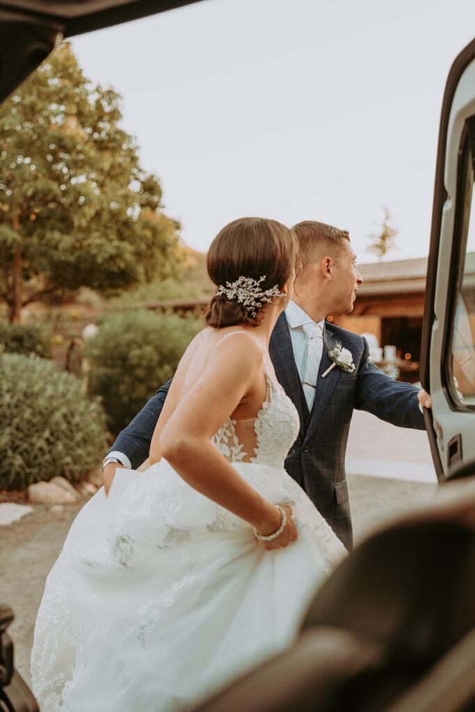 bride and groom getting in a car
