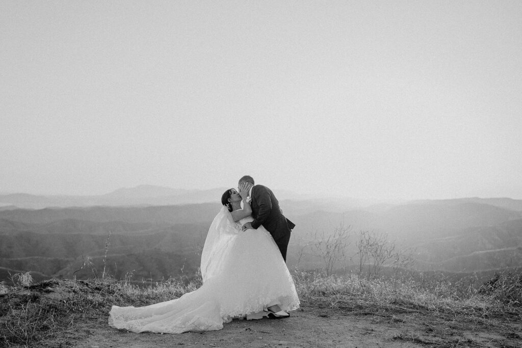 black and white sunset photo of bride and groom