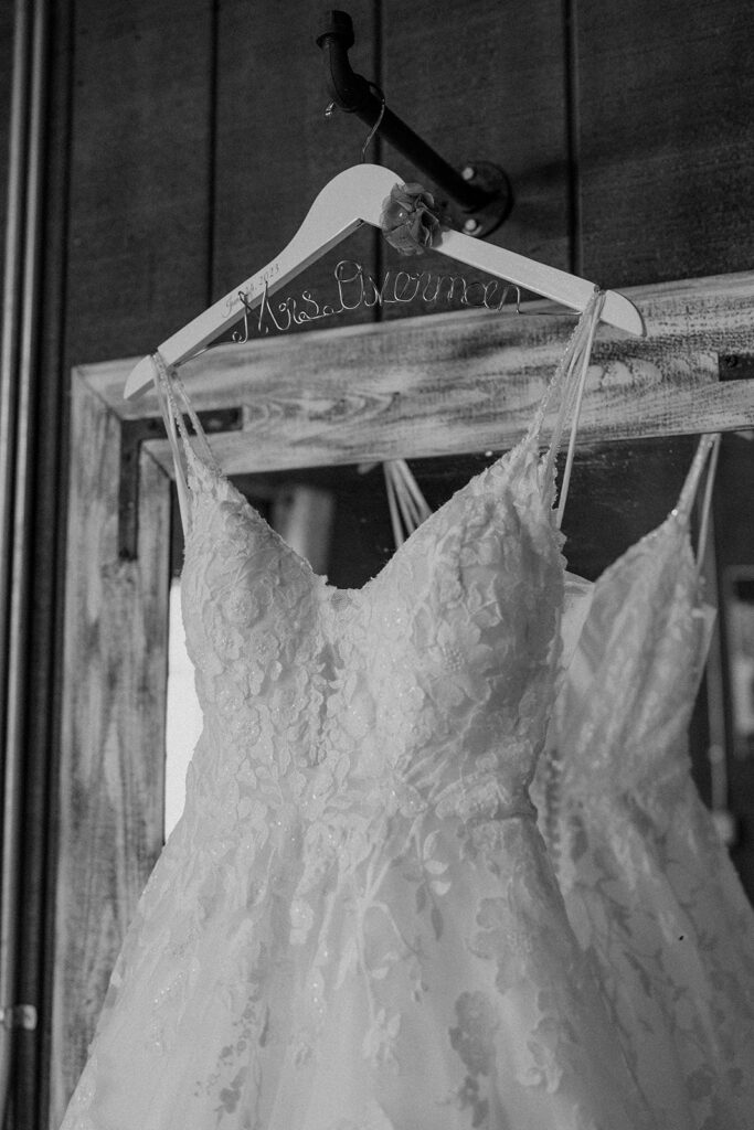 black and white photo of a wedding dress hanging up