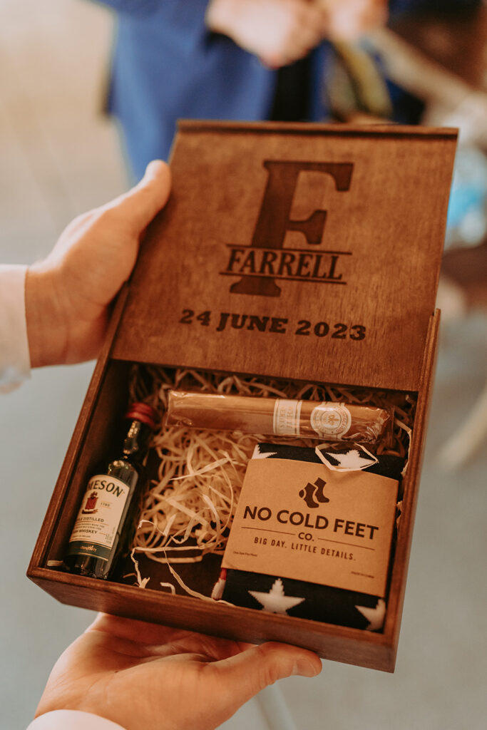 wooden box with a grooms cigar, whiskey, and socks