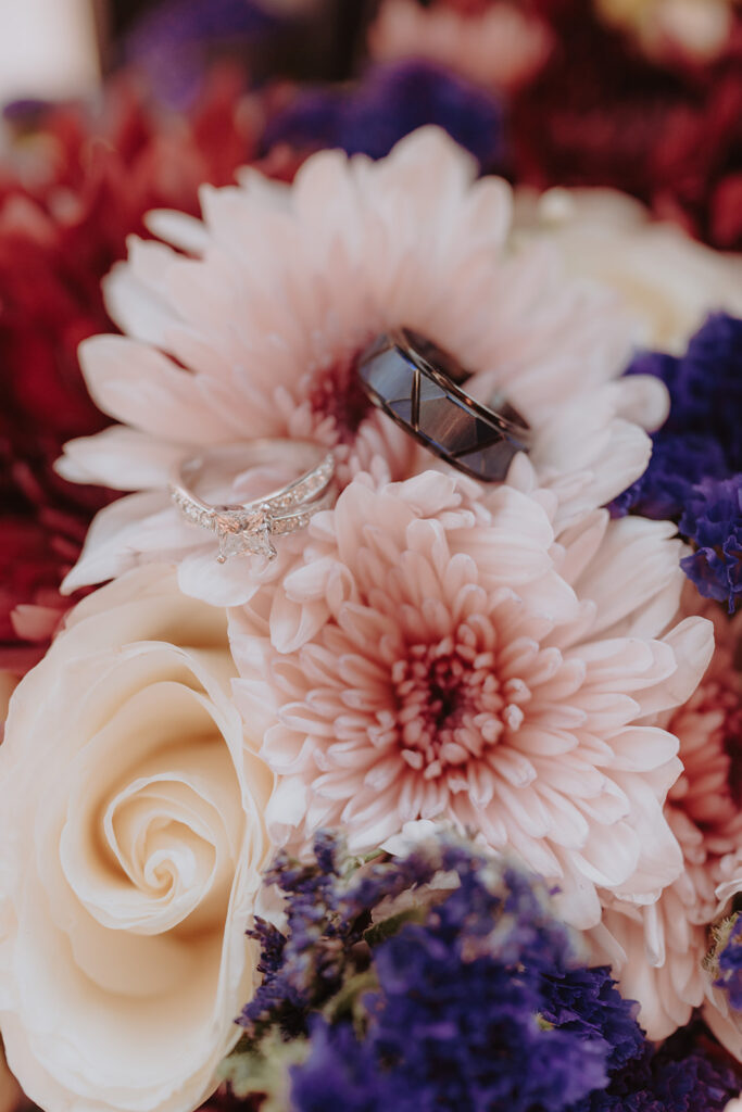 detail photo of wedding rings on flowers