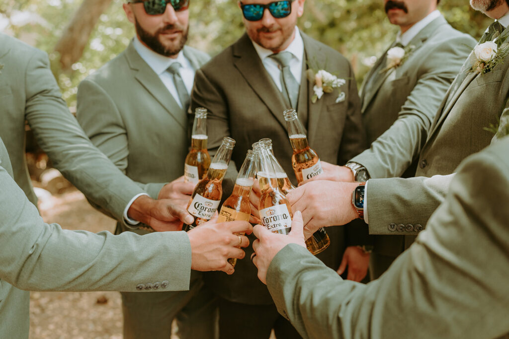 groom and groomsmen cheering with beers