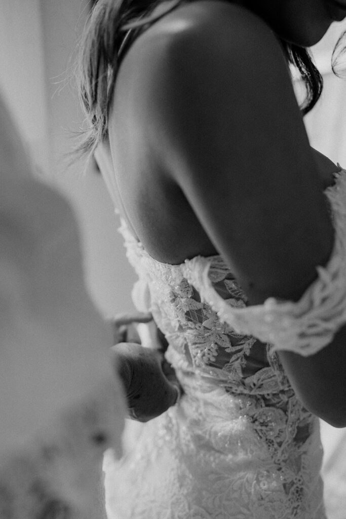 a bride getting her dress zipped up