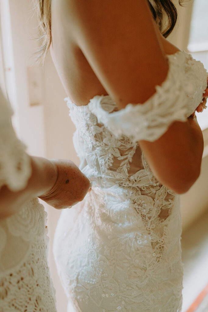 a bride getting her dress zipped up