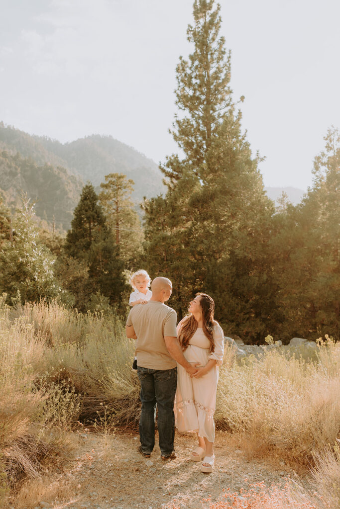 Fall maternity session in the Southern California mountains during golden hour, featuring warm autumn tones and stunning mountain views