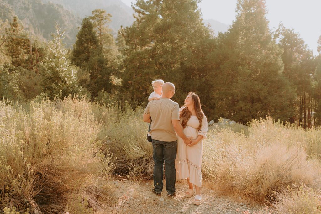 Fall maternity session in the Southern California mountains during golden hour, featuring warm autumn tones and stunning mountain views