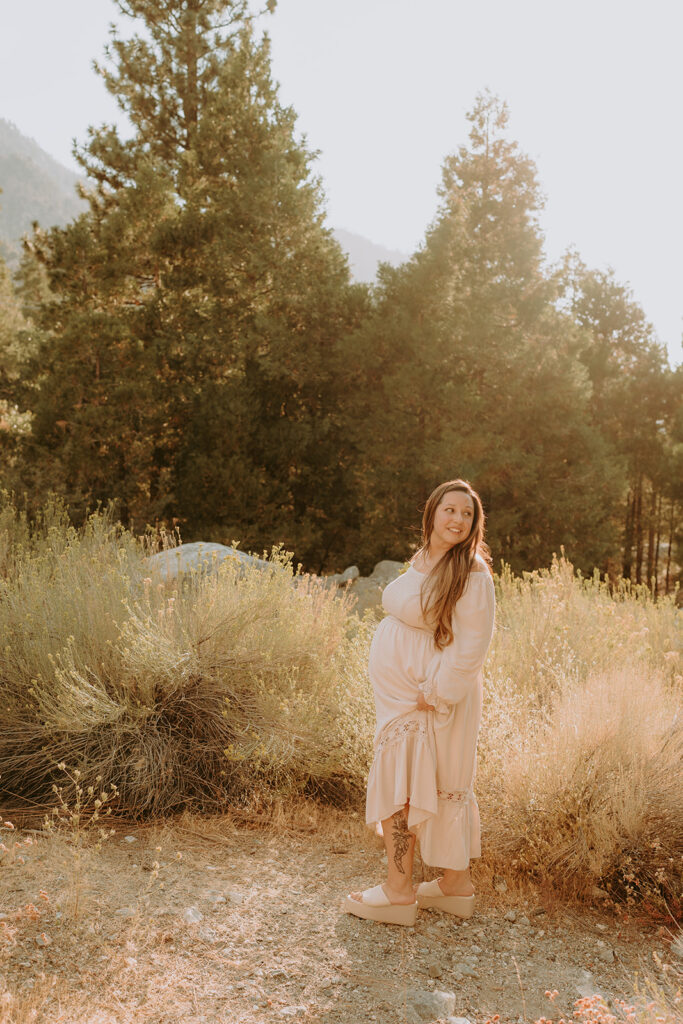 Fall maternity session in the Southern California mountains during golden hour, featuring warm autumn tones and stunning mountain views