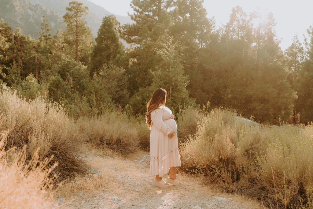 Fall maternity session in the Southern California mountains during golden hour, featuring warm autumn tones and stunning mountain views