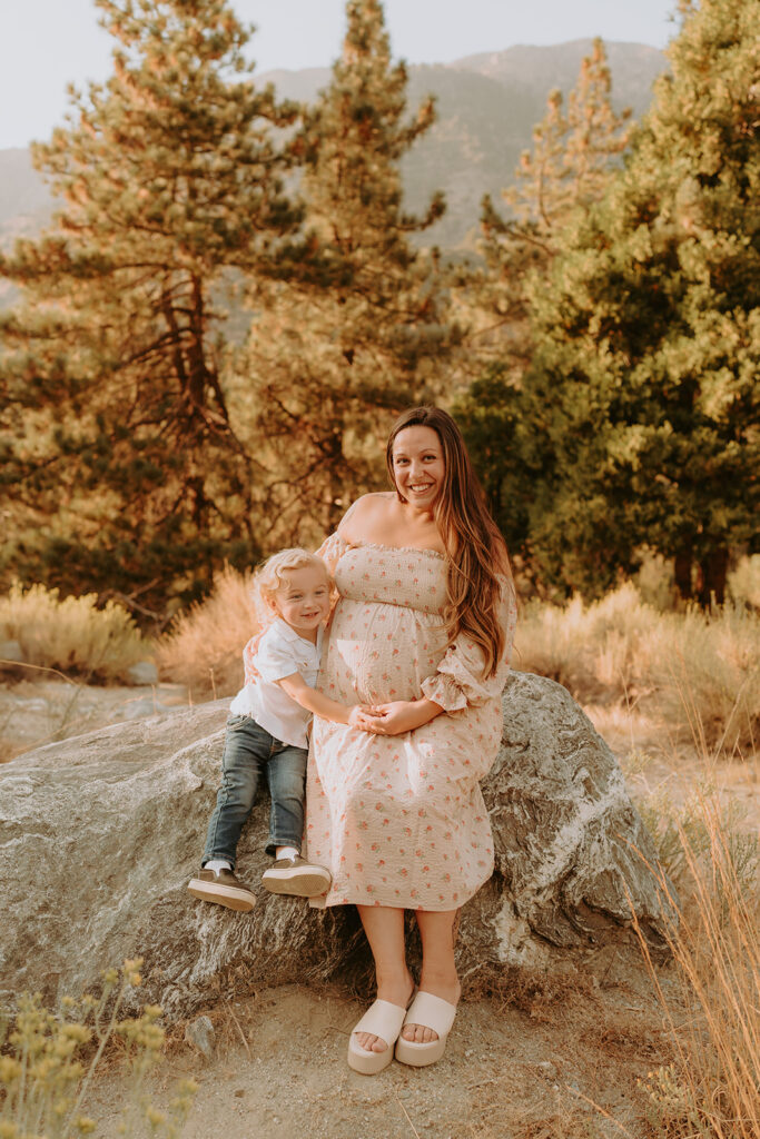 Fall maternity session in the Southern California mountains during golden hour, featuring warm autumn tones and stunning mountain views