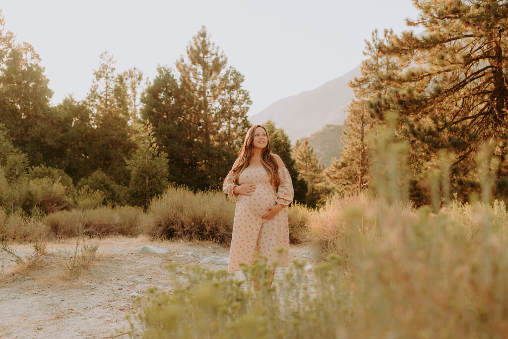 Fall maternity session in the Southern California mountains during golden hour, featuring warm autumn tones and stunning mountain views