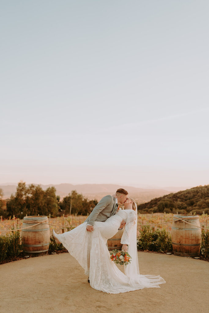 Bride in a flowing gown standing at Sacred Oak Vineyard, ideal for romantic outdoor wedding photography