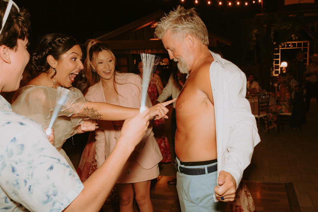 Candid photo of bride laughing after seeing her dad’s tattoo