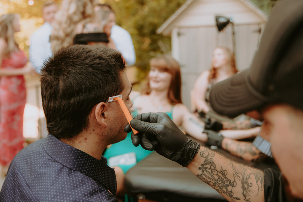 Tattoo artists setting up flash sheet during cocktail hour – unique wedding idea
