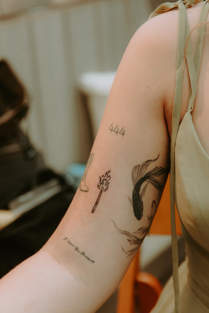 Tattoo artists setting up flash sheet during cocktail hour – unique wedding idea