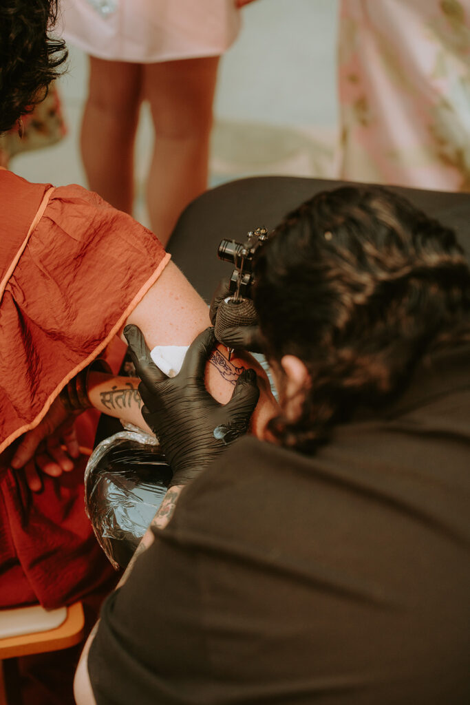 Tattoo artists setting up flash sheet during cocktail hour – unique wedding idea