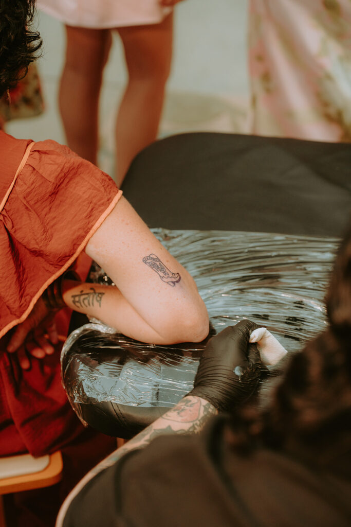 Tattoo artists setting up flash sheet during cocktail hour – unique wedding idea