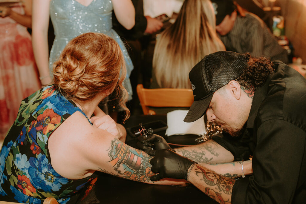 Tattoo artists setting up flash sheet during cocktail hour – unique wedding idea